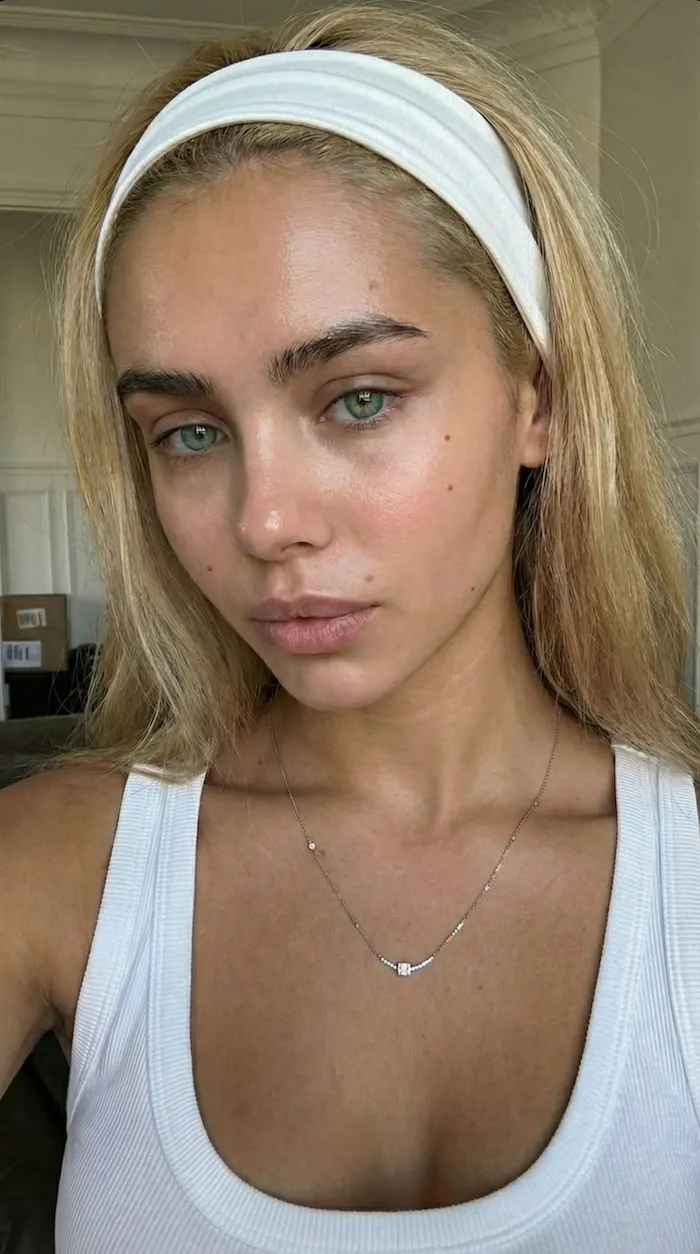 Headshot reference of a young woman with blonde hair and a white headband, light makeup, white tank top — used as identity anchor for the night motorcycle portrait edit