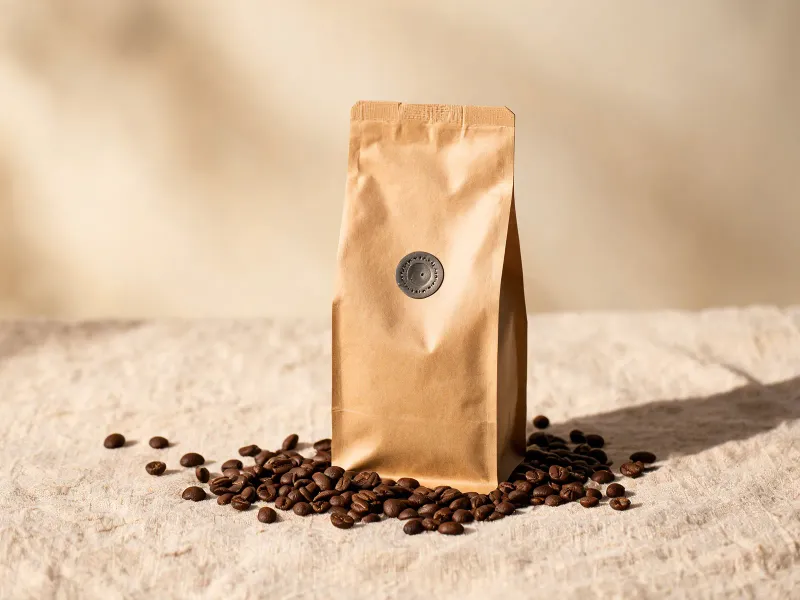 Coffee bag standing upright on raw linen cloth surrounded by scattered whole coffee beans, warm natural side lighting, photorealistic product shot