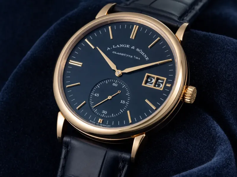 Macro close-up of a watch on a dark navy velvet surface, sharp focus on the dial and indices, soft falloff into the strap, luxury editorial product photography