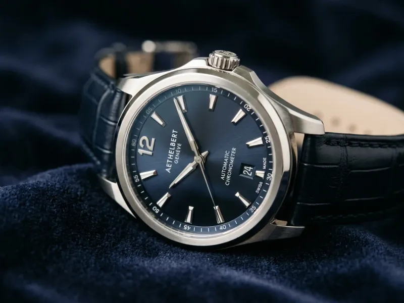 Macro close-up of a watch on a dark navy velvet surface, sharp focus on the dial and indices, soft falloff into the strap, luxury editorial product photography